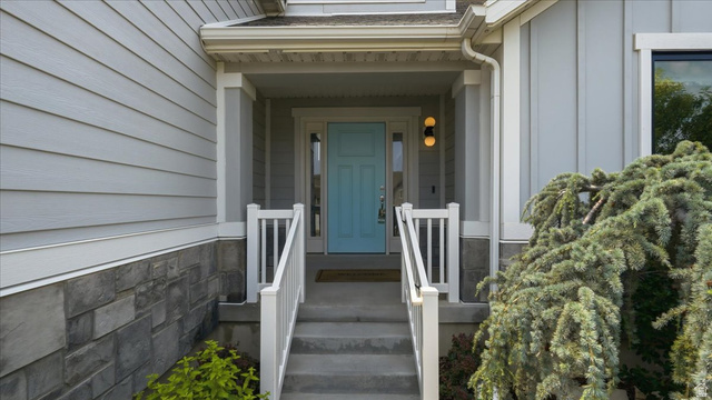 2038 East Ranch Road Eagle Mountain, UT 84005 - Photo 6 of 66 Inviting entryway featuring a light blue door, concrete steps with white railings, and a covered porch