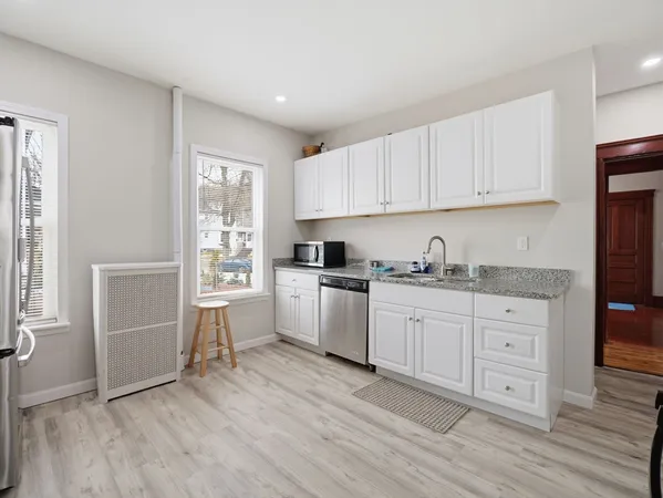 a work room with furniture a rug and a window
