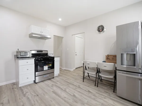 a kitchen with granite countertop white cabinets and stainless steel appliances