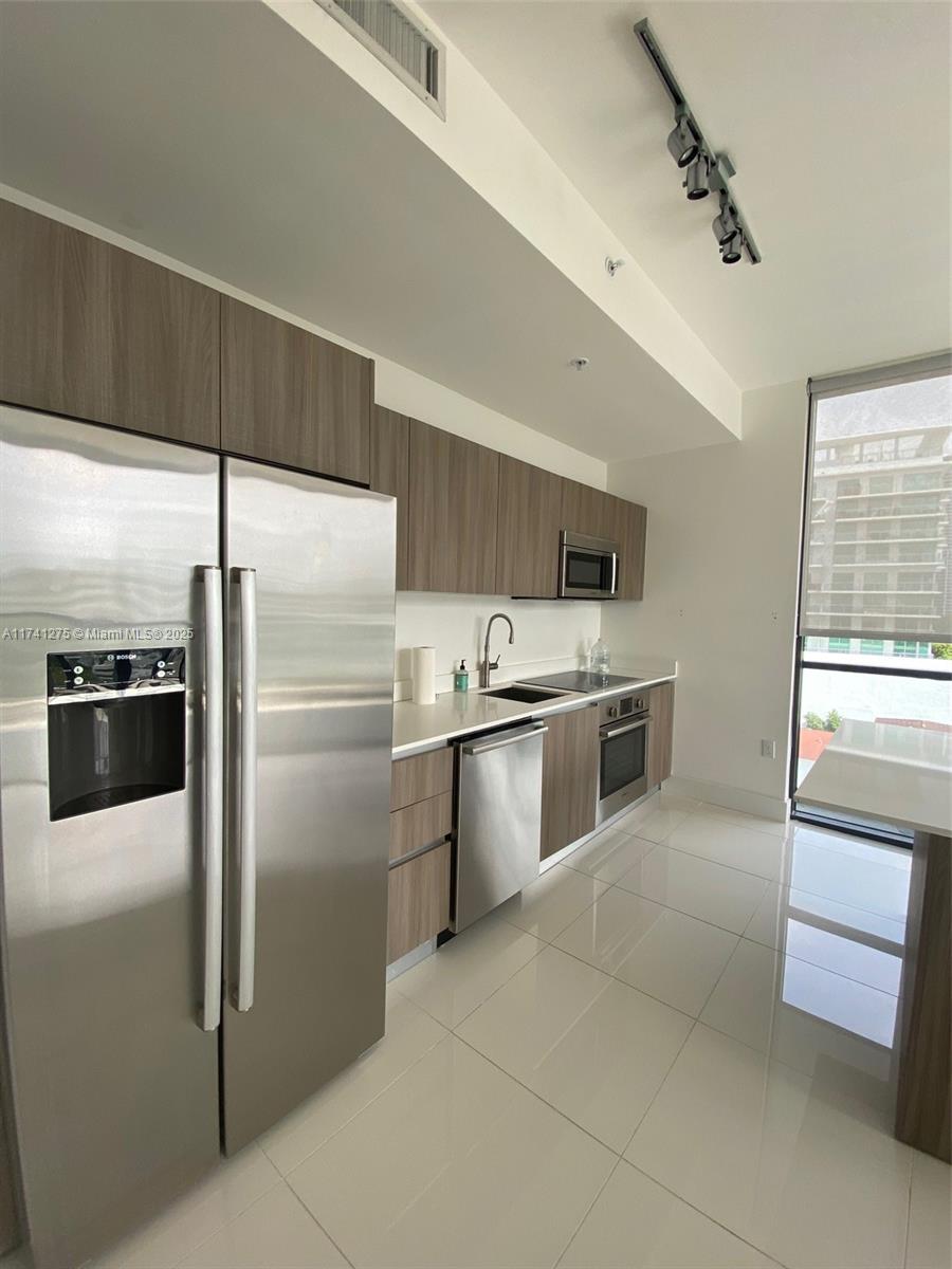 201 Southwest 17th Road, Unit 806 Miami, FL 33129 - Photo 3 of 10 a kitchen with a refrigerator sink and cabinets