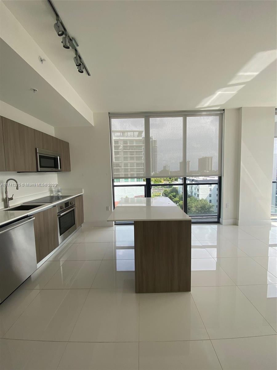 201 Southwest 17th Road, Unit 806 Miami, FL 33129 - Photo 4 of 10 a kitchen with stainless steel appliances a stove a sink and a microwave