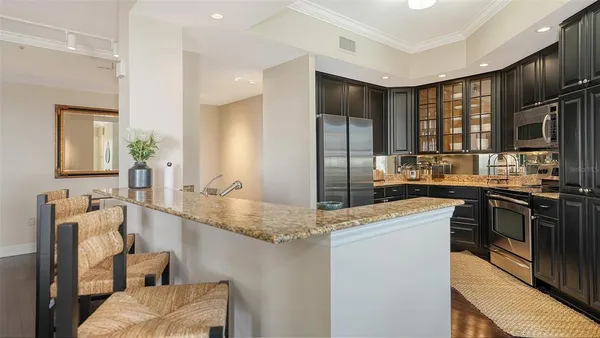 a kitchen with stainless steel appliances granite countertop a sink stove and refrigerator