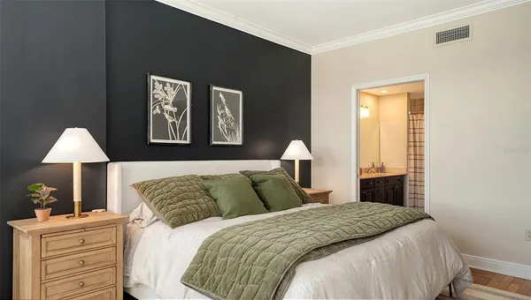 a bedroom with a bed and a lamp on the dresser