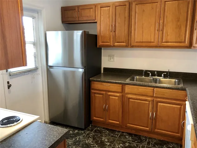 a kitchen with stainless steel appliances granite countertop a refrigerator and a stove