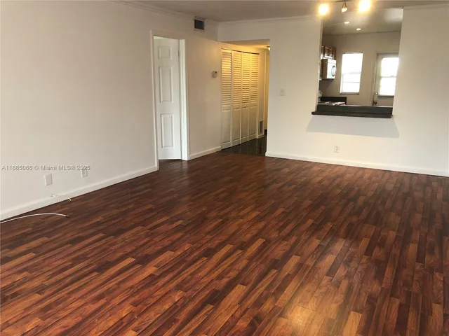 an empty room with wooden floor and a window