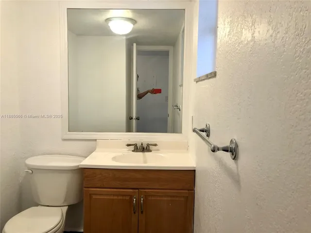 a bathroom with a sink mirror and toilet