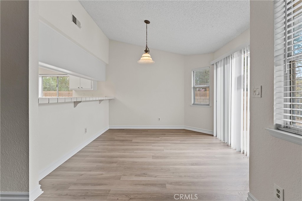 43610 16th Street East Lancaster, CA 93535 - Photo 6 of 21 an empty room with wooden floor cabinet and windows