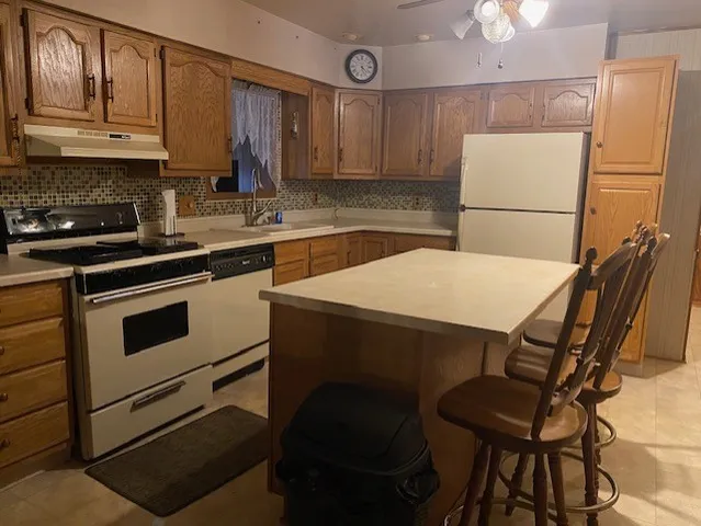 a kitchen with a dining table chairs and refrigerator