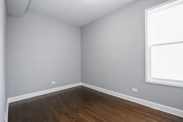 a view of a small space with wooden floor and a window