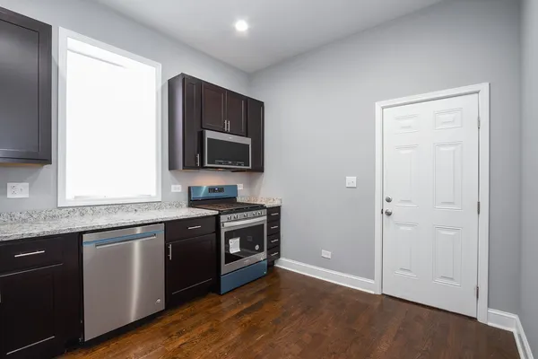 a kitchen with stainless steel appliances granite countertop a stove a sink and a microwave