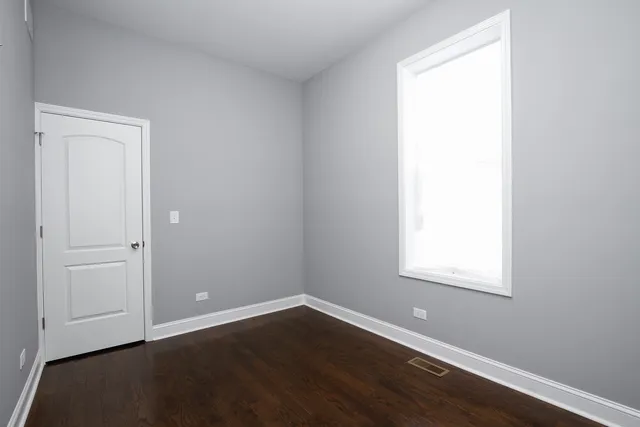 an empty room with wooden floor and closet