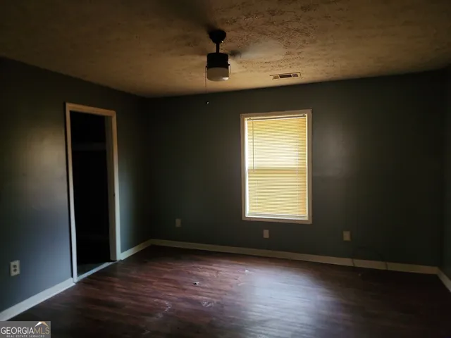 an empty room with wooden floor and a window