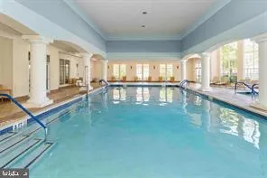 a large white kitchen with swimming pool and furniture