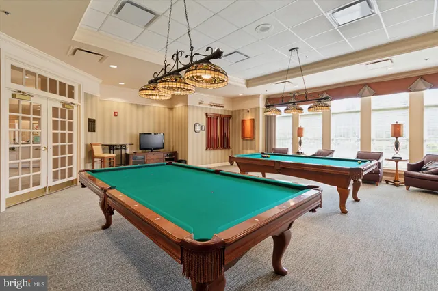 a room with pool tables and a chandelier