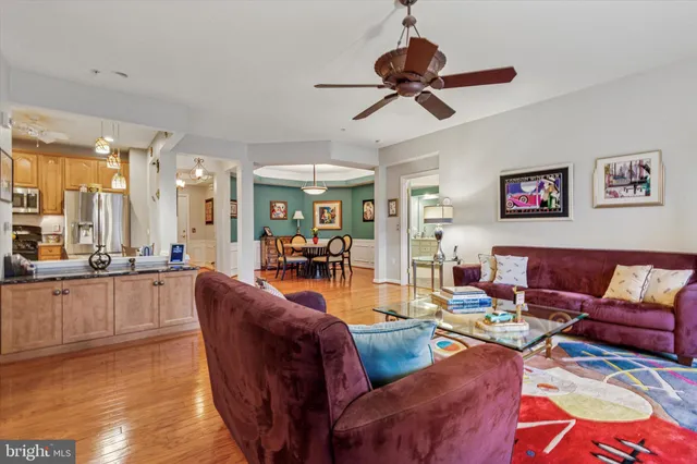 a living room with furniture kitchen view and a wooden floor