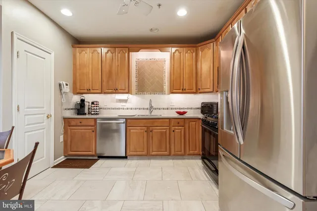 a kitchen with a refrigerator sink and cabinets