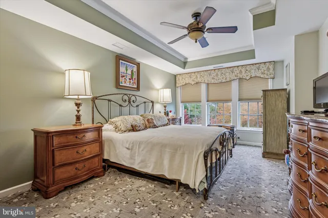 a bedroom with a bed a chandelier and a dresser