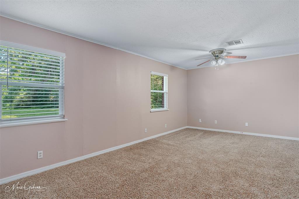 9342 Dean Road Shreveport, LA 71118 - Photo 11 of 18 Spacious room featuring neutral carpeting, a ceiling fan with integrated lighting, and multiple windows with horizontal blinds