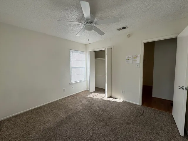 an empty room with a ceiling fan and a window