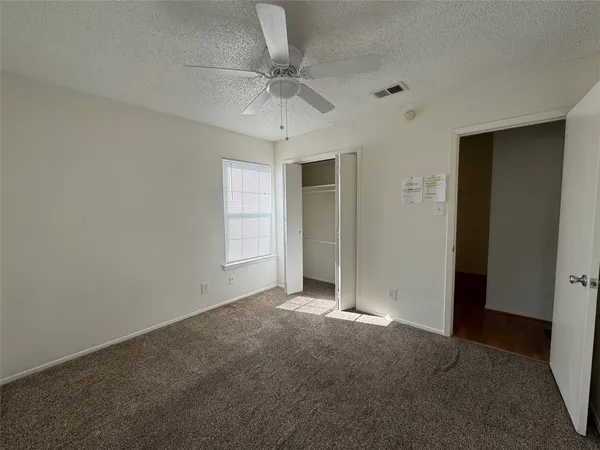 an empty room with a ceiling fan and a window