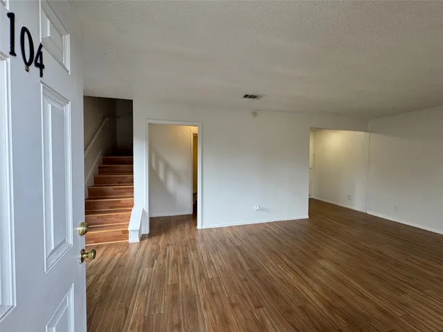 a view of a hallway with wooden floor and stairs