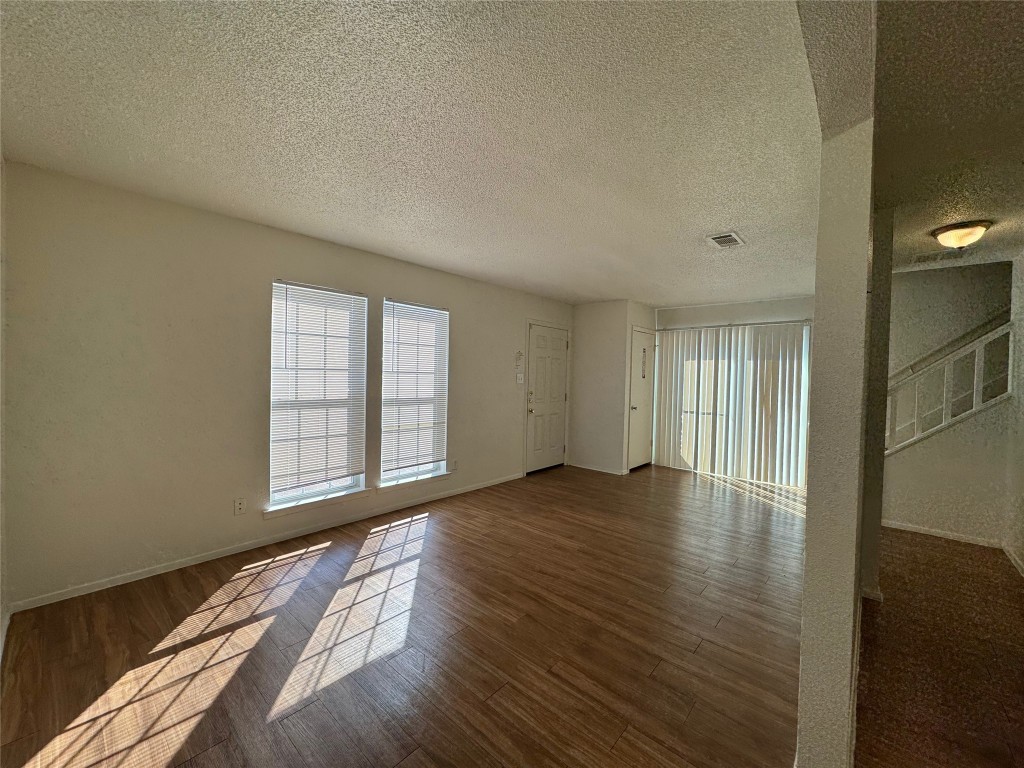 4810 West Wind Trail, Unit 104 Austin, TX 78745 - Photo 4 of 21 a view of an empty room with wooden floor and a window