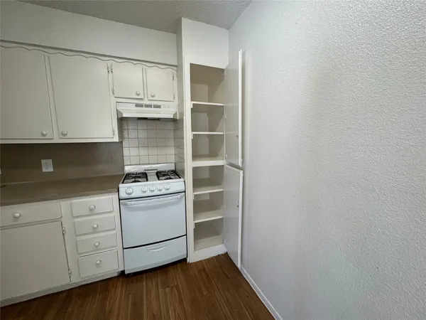 a kitchen with granite countertop white cabinets and white appliances