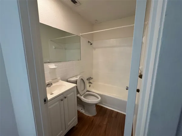 a bathroom with a granite countertop sink a toilet and shower