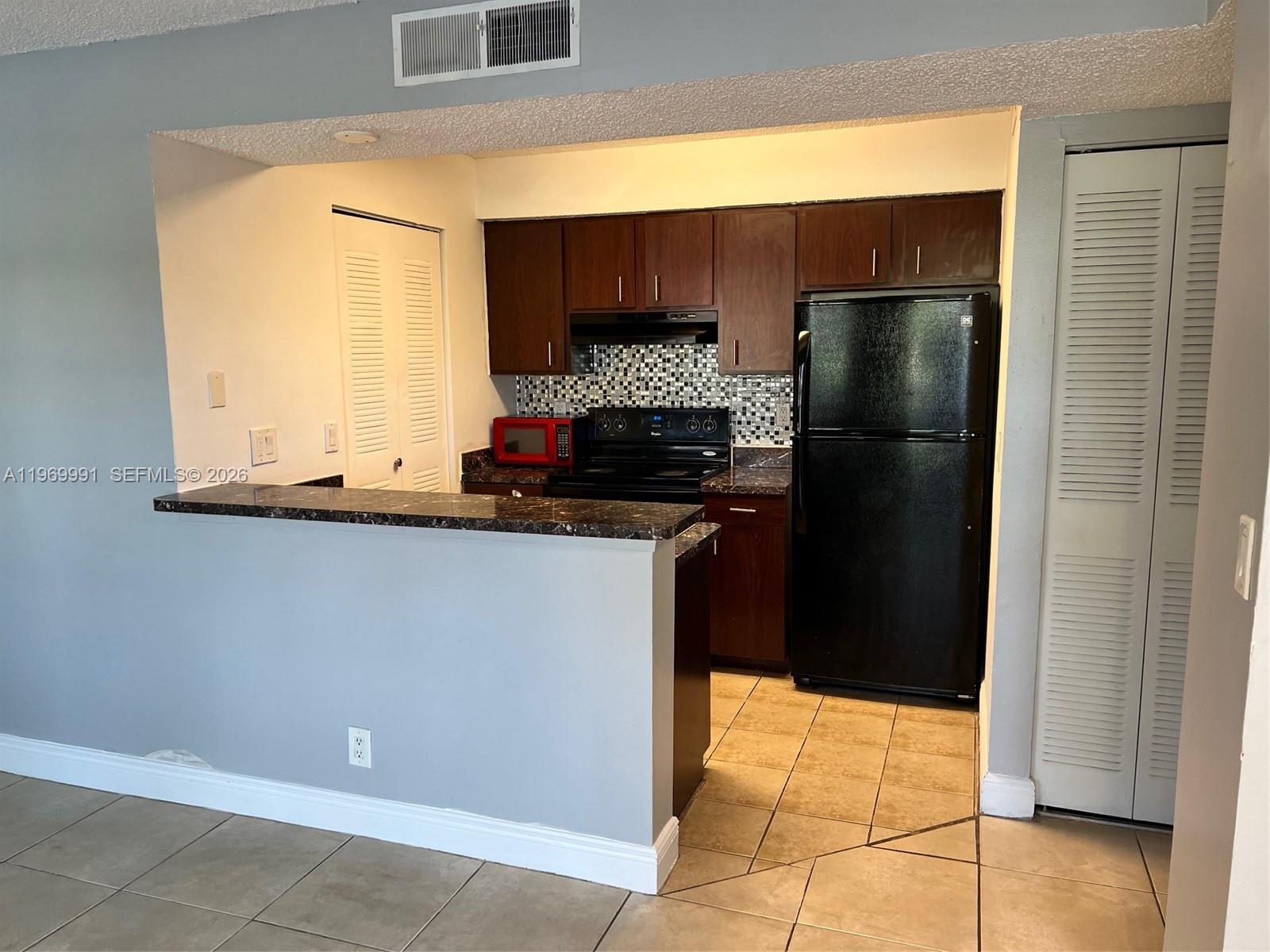 a kitchen with a refrigerator and a window