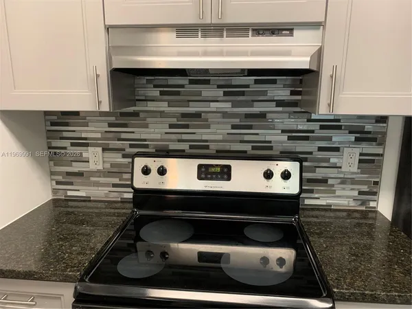 a stove top oven sitting inside of a kitchen