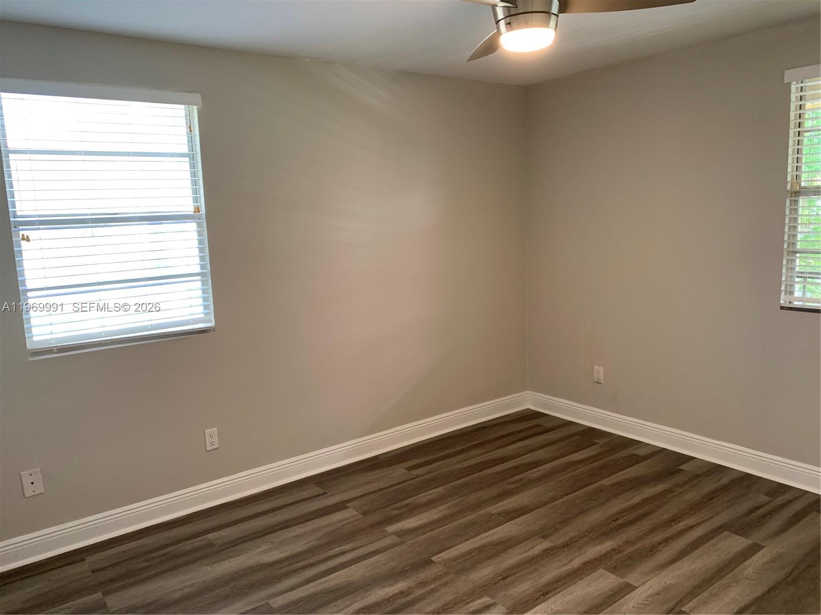 1261 Southwest 46th Avenue, Unit 2004 Pompano Beach, FL 33069 - Photo 3 of 9 a view of a small space with wooden floor and a window