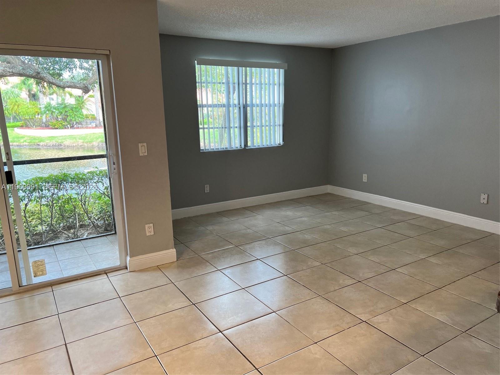 1261 Southwest 46th Avenue, Unit 2003 Pompano Beach, FL 33069 - Photo 3 of 9 a view of an empty room with a window
