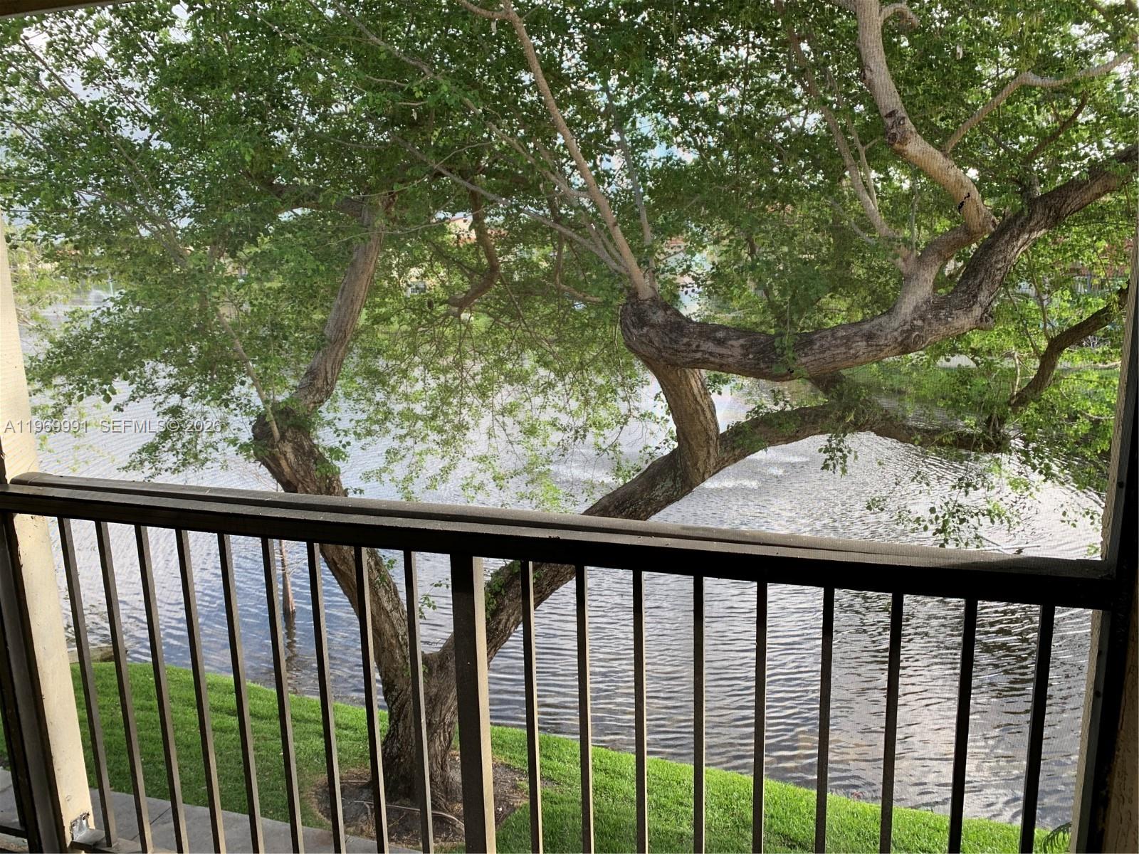 1261 Southwest 46th Avenue, Unit 2004 Pompano Beach, FL 33069 - Photo 7 of 9 a balcony with trees in front of it