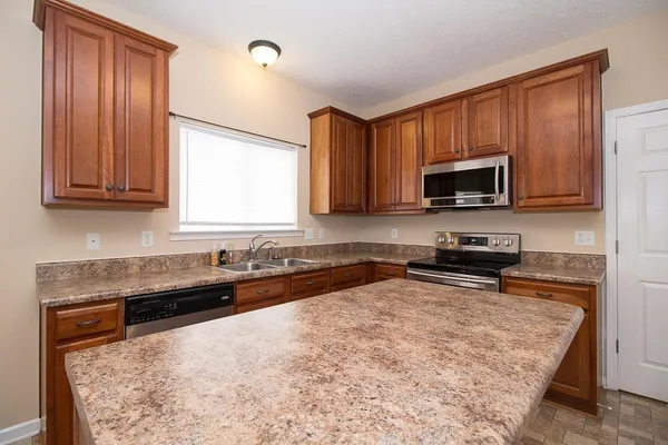 a kitchen with a sink a microwave and wooden cabinets