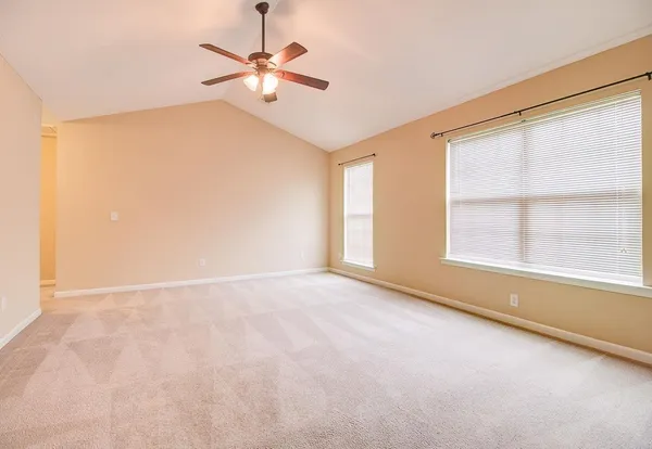 an empty room with windows and fan
