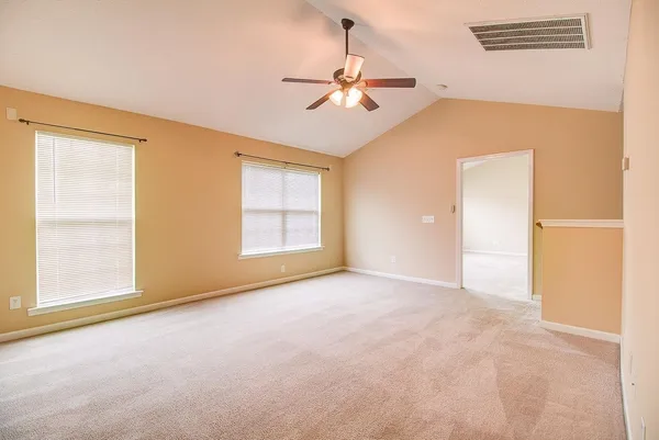 an empty room with windows and fan