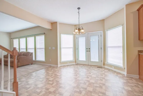 a view of a livingroom with a chandelier fan and windows