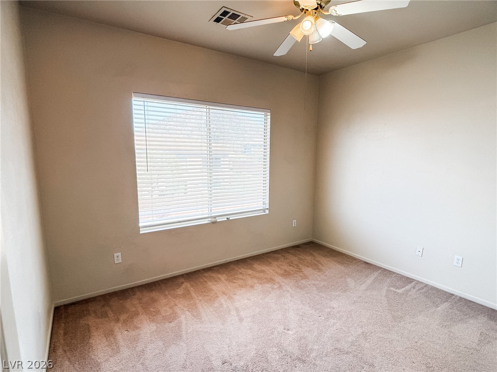 228 Positive Point Street Henderson, NV 89012 - Photo 21 of 27 A well-lit bedroom featuring a ceiling fan and soft carpeting, awaiting your personal touch.