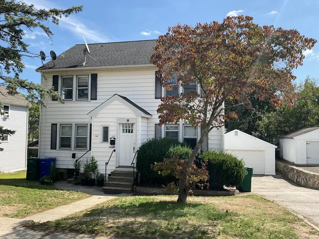 a front view of a house with a yard and potted plants