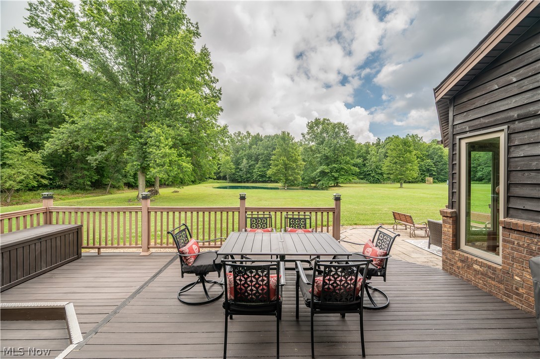 405 Airport Road Northwest Warren, OH 44481 - Photo 43 of 50 Expansive wood-finish deck with a wood railing and post caps, bordered by an open lawn and mature trees