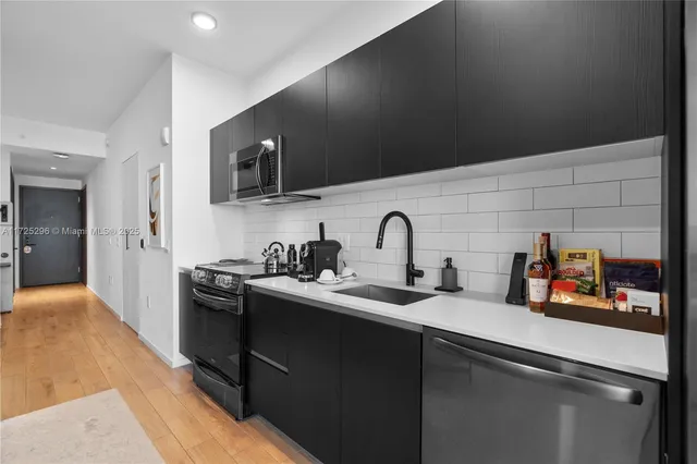 a kitchen with a stove and a wooden floor