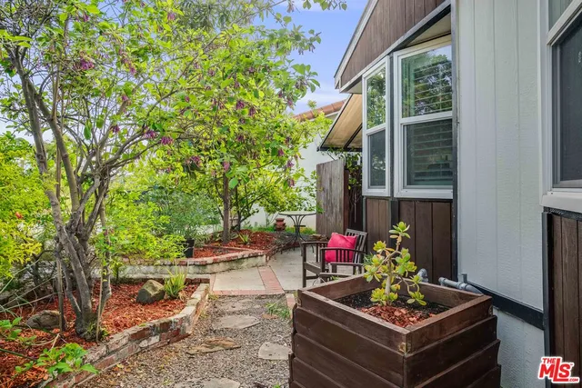 a view of a chair and tables in backyard of the house