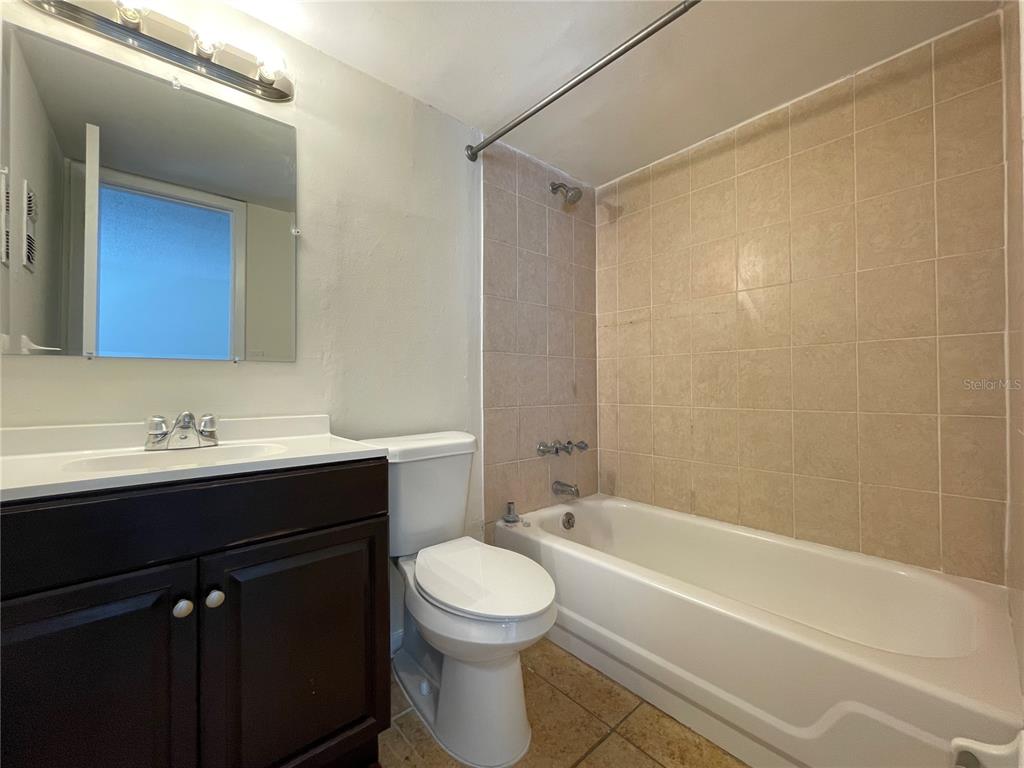 5254 Davisson Avenue, Unit 5254 Orlando, FL 32810 - Photo 11 of 15 a bathroom with a bathtub a sink a toilet and a mirror