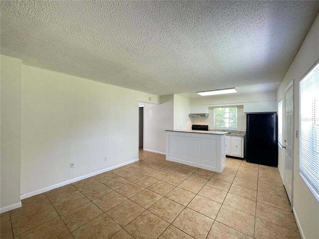 5254 Davisson Avenue, Unit 5254 Orlando, FL 32810 - Photo 3 of 15 a large kitchen with a refrigerator and a stove top oven