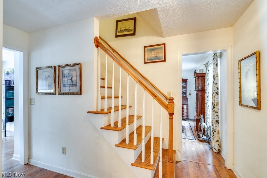 136 Taylor Road Barberton, OH 44203 - Photo 4 of 45 Staircase featuring wood finished floors and a textured ceiling