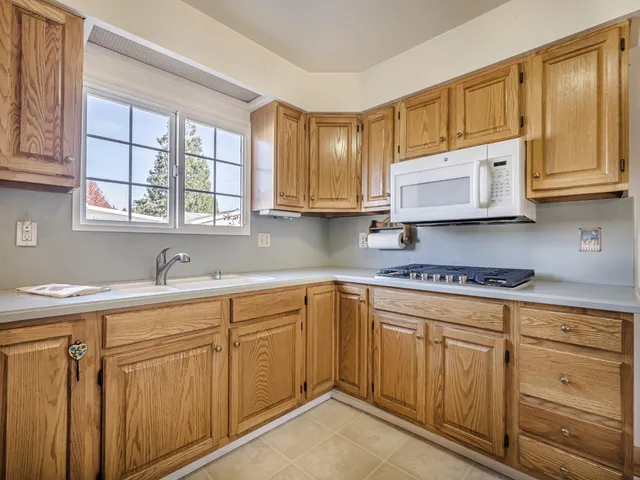 a kitchen with cabinets appliances a sink and a window