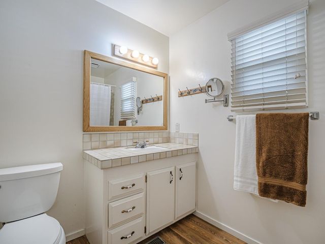 a bathroom with a toilet a sink a vanity and mirror