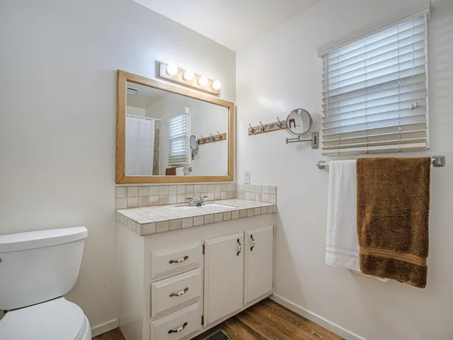 a bathroom with a toilet a sink a vanity and mirror