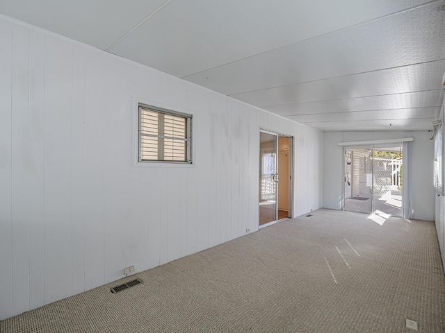 a view of a bedroom with wooden floor and windows