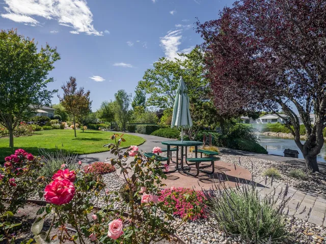 a view of a table and chairs in backyard of the house